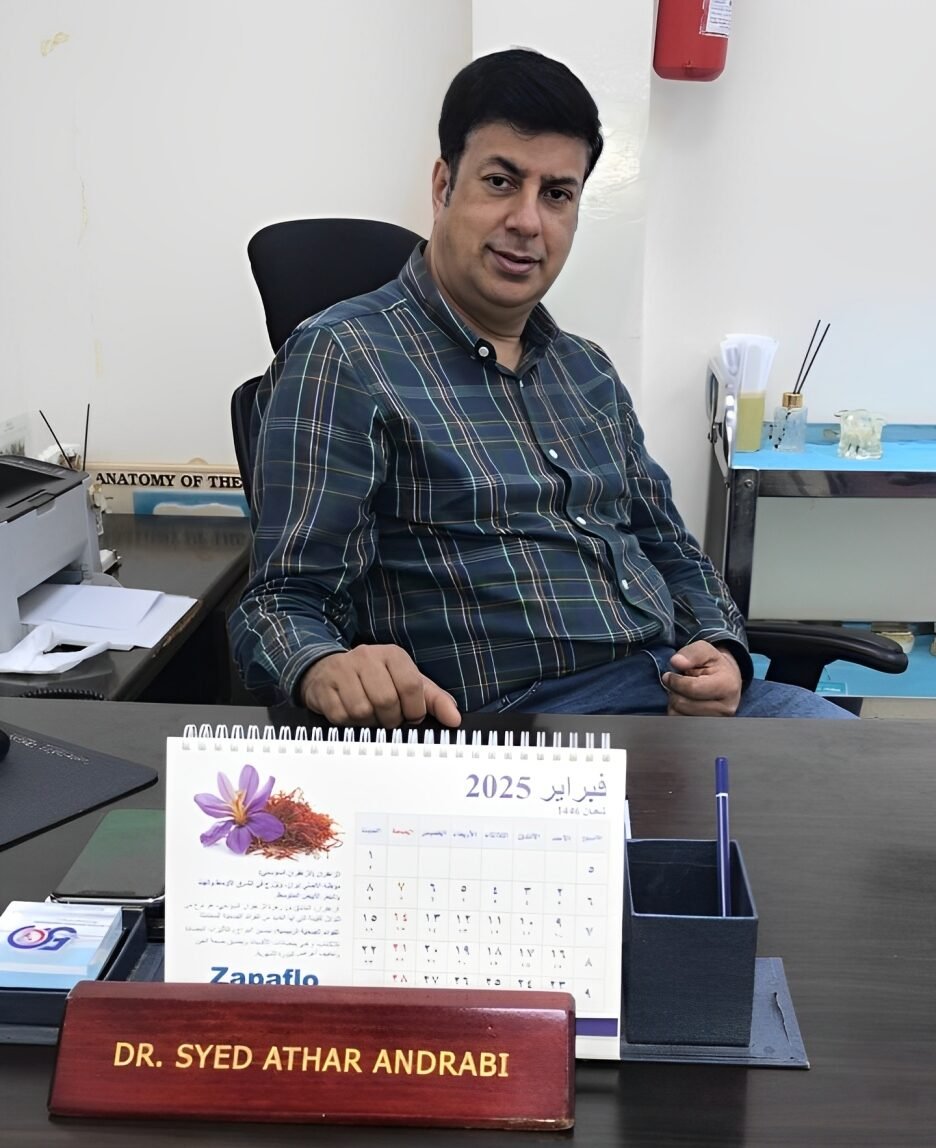 Dr. Syed Athar Andrabi, a dedicated healthcare professional at Al Farooq Clinic, sitting at his office desk, providing expert medical care and consultations in Oman.